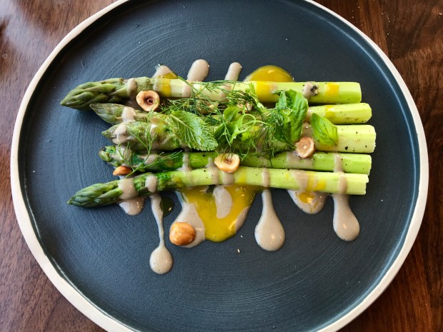 Inferno Pizzeria Napoletana tender roasted asparagus with sauces of black truffle and egg yolk, topped with crunchy hazelnuts